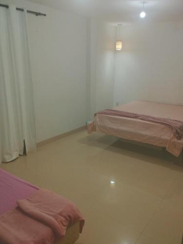 a room with two beds with pink sheets at Casa Sobrado Confortavel, Descanso Garantido in Cuiabá