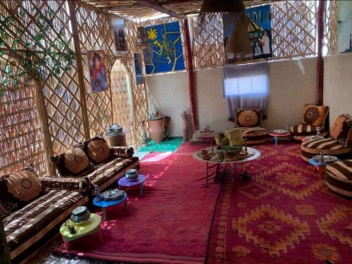 a living room with couches and a red rug at Château Berbère Madame DELLAL in Taroudant