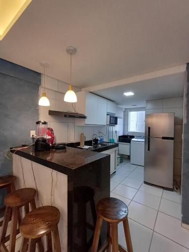 a kitchen with a counter and some stools in it at proximo ao ct do America in Parnamirim