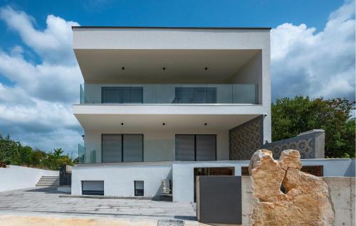 a house on the beach with a large building at Beautiful Apartment In Vodnjan in Barbariga
