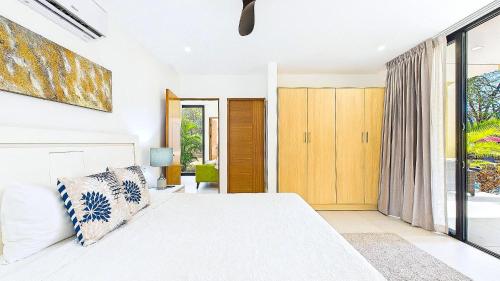 a bedroom with a white bed and a large window at Catalina Cove 45 - Luna Piena Private Home in Brasilito