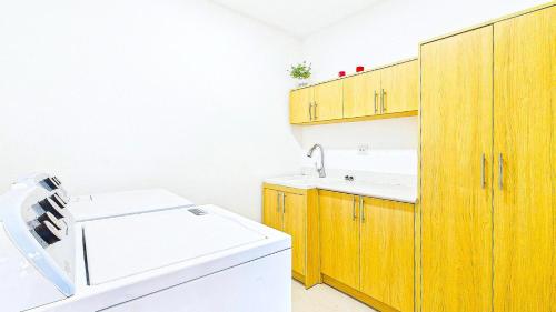 a kitchen with wooden cabinets and a washing machine at Catalina Cove 45 - Luna Piena Private Home in Brasilito