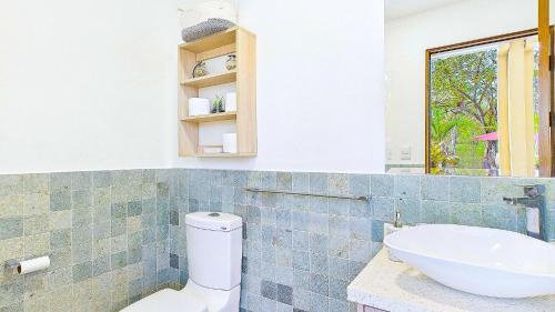 a bathroom with a white toilet and a sink at Catalina Cove 45 - Luna Piena Private Home in Brasilito