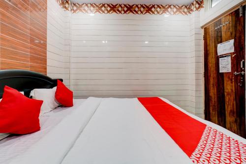 a bed with red pillows in a room at Hotel O Aroma Classic Near Nampally Main Railway station in Hyderabad