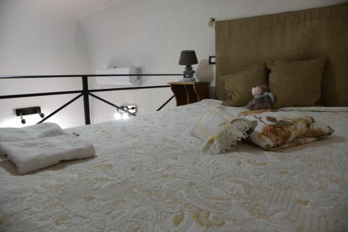 a teddy bear sitting on top of a bed at Appartamento in centro- Enea home in Agrigento