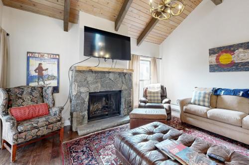 a living room with a fireplace and a tv at Breakaway West in Vail