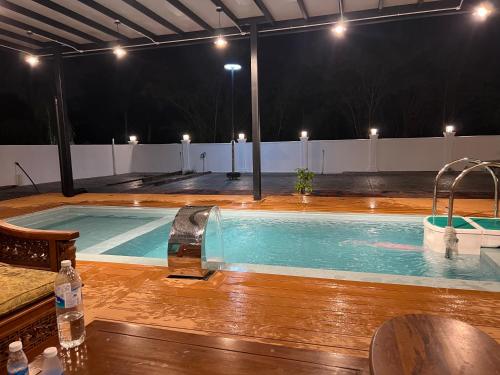 a large swimming pool with a wooden floor and lights at KLIA HBO Villa Homestay in Nilai