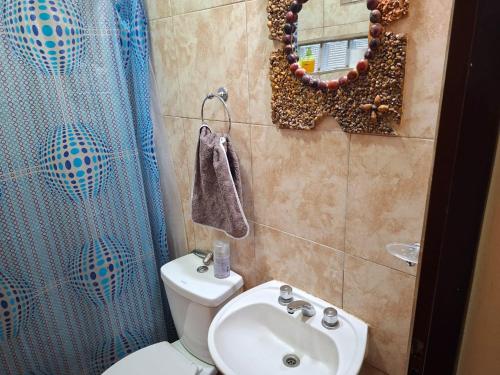a bathroom with a toilet and a sink and a mirror at Finca El Algarrobo, confort y excelente ubicación in Santiago del Estero