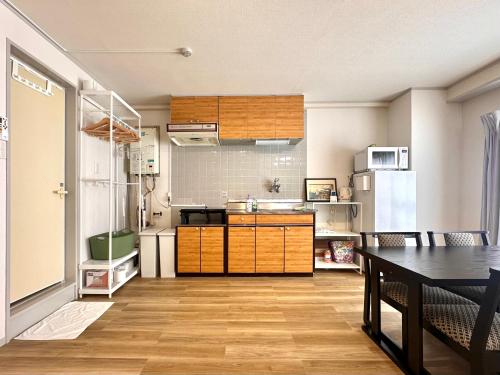 a kitchen with a table and a refrigerator at IKEBUKURO LoveSugamo 交通便利 山手線巣鴨駅徒歩3分 池袋駅4分 2ー4人 エレベーター WIFI 新宿 渋谷 銀座 浅草 銀座 原宿アクセス便利 空港直通 in Tokyo