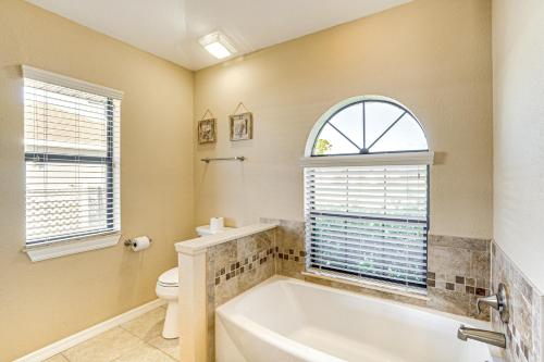 a bathroom with a tub and a toilet and a window at Near Golf and Beaches Luxe Home in Rotonda West! in Rotonda West