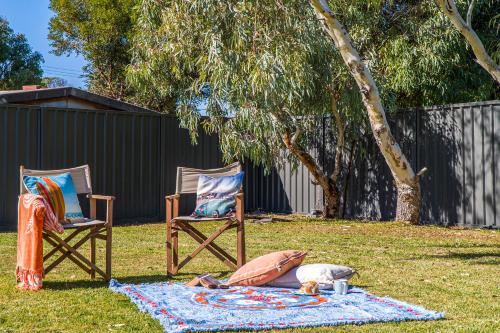 two chairs and a dog on a blanket in a yard at Break-A-Way - Coastal comfort in lancelin in Lancelin