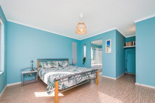 a bedroom with blue walls and a bed at Break-A-Way - Coastal comfort in lancelin in Lancelin