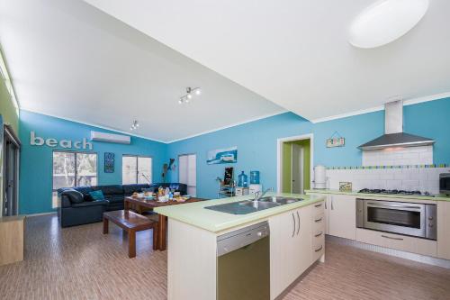 a kitchen and living room with blue walls at Break-A-Way - Coastal comfort in lancelin in Lancelin