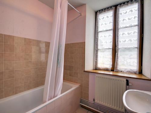 un bagno con vasca, lavandino e finestra di Gîte familial avec jardin clos, idéal pour randonnées et escapades nature, animaux acceptés - FR-1-496-196 a La Chambonie