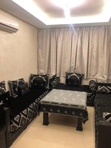 a living room with chairs and a table and a window at Nour sakane in Oulad Akkou