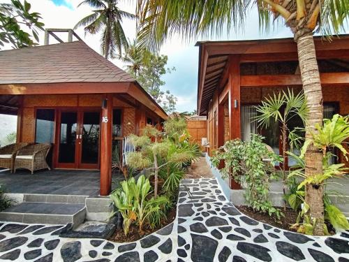 a house with a porch and a patio at Scallywags Beach Club in Gili Air