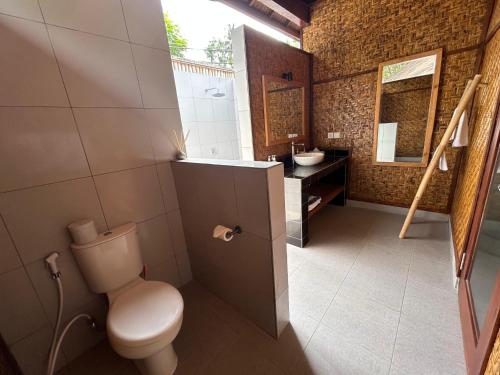 a bathroom with a toilet and a sink at Scallywags Beach Club in Gili Air