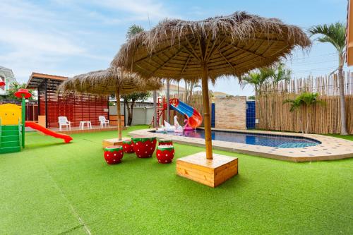 a playground with an umbrella and a slide at The Orange House Pool Villa Pattaya in Jomtien Beach