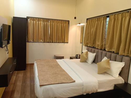 a bedroom with a large bed and a television at The Urban Escape in Trimbak