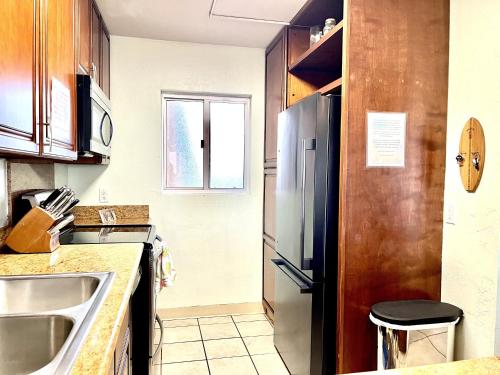 a kitchen with a sink and a refrigerator at Menehune Shores 227 condo in Kihei