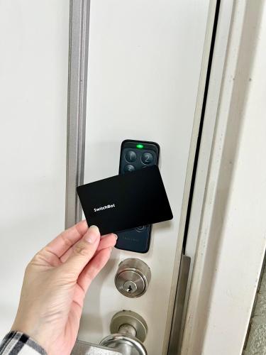 a person holding a card in front of a door at サザンビーチ近く Seaside Villa 湘南茅ヶ崎 202 2DK 38m2 in Chigasaki