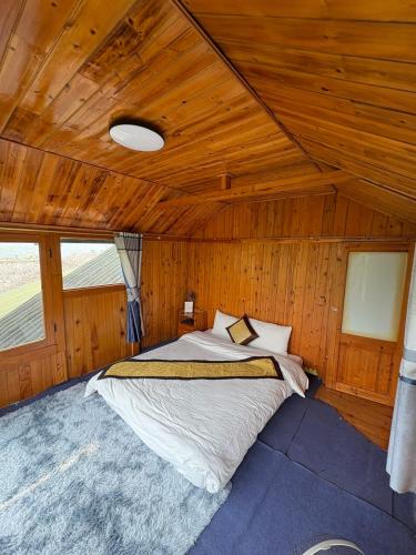 a bed in a room with a wooden ceiling at Sapa Eco Hugo in Sa Pa