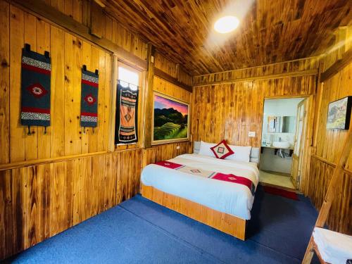a bedroom with a bed in a wooden room at Sapa Eco Hugo in Sa Pa