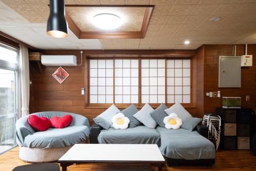 a living room with two couches and red pillows at 和風の二階建て一戸建て 国際通りまで500m in Naha
