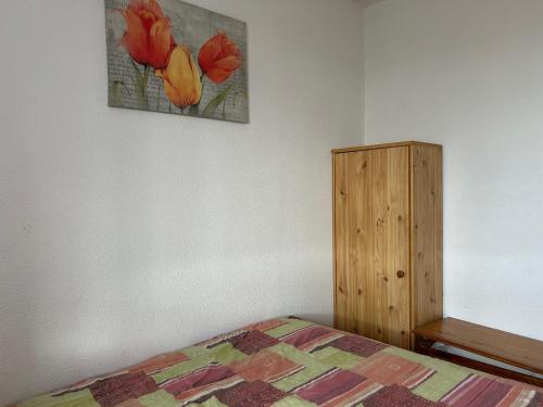 une chambre avec un lit et une armoire en bois dans l'établissement Appartement T2 Saint Cyprien - 4 pers, parking - FR-1-793-35, à Saint-Cyprien