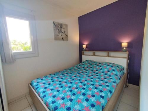 - une chambre avec un lit doté d'un couvre-lit bleu et d'une fenêtre dans l'établissement T2 Saint-Pierre-La-Mer - Parking - 3/4 pers - FR-1-795-63, à Fleury