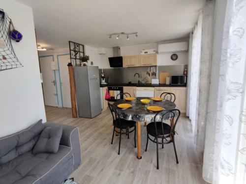 une cuisine et un salon avec une table et des chaises dans l'établissement Appartement T3 avec climatisation et parking, proche plage, 4 pers, Narbonne-Plage - FR-1-795-65, à Narbonne