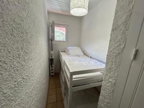 une petite pièce avec un lit et une fenêtre dans l'établissement Appartement climatisé pour 4 personnes proche plage - FR-1-837-6, à Argelès-sur-Mer