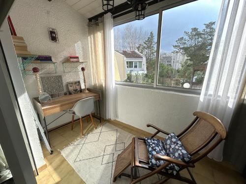 une chaise dans une chambre avec un bureau et une fenêtre dans l'établissement Maison climatisée avec parking près de la plage - FR-1-837-3, à Argelès-sur-Mer