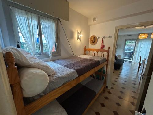 un lit dans une chambre avec une grande fenêtre dans l'établissement Appartement 4 pers. au Racou avec parking, proche plage - FR-1-837-7, à Argelès-sur-Mer