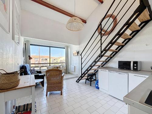 une cuisine avec un escalier et un salon dans l'établissement CARNON - F2 Mezzanine tout confort sur port, rénové et bien équipé - FR-1-715-105, à Mauguio