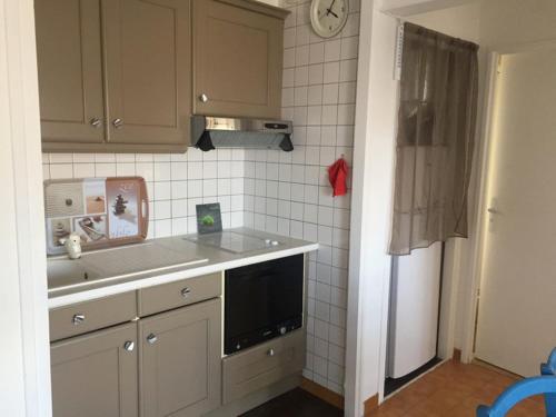 une cuisine avec un évier et un micro-ondes dans l'établissement Appartement sur la plage pour 4 personnes avec parking - FR-1-837-5, à Argelès-sur-Mer