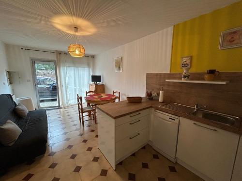 une cuisine avec un évier et une table avec un canapé dans l'établissement Appartement 4 pers. au Racou avec parking, proche plage - FR-1-837-7, à Argelès-sur-Mer