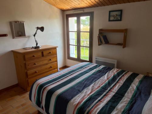 une chambre avec un lit et une lampe sur une commode dans l'établissement Maison à Noirmoutier 6 pers, Animaux admis, Wifi - FR-1-823-158, à Noirmoutier-en-l'lle