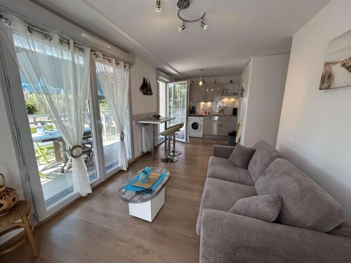 un salon avec un canapé et une table dans l'établissement Appartement moderne 2 pièces, 4 couchages, terrasse et parking sécurisé à Saint-Jean-de-Monts - FR-1-224C-351, à Saint-Jean-de-Monts