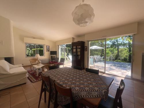 une salle à manger avec une table et un canapé dans l'établissement Maison 110 m² Pyla-sur-Mer avec Terrasse et Jardin, proche plages - FR-1-420-161, à La Teste-de-Buch