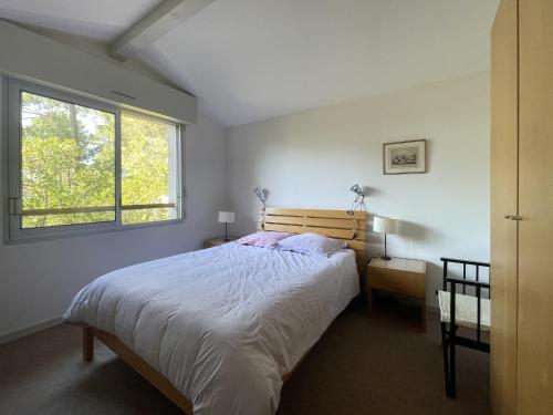 une chambre avec un grand lit et une fenêtre dans l'établissement Maison 110 m² Pyla-sur-Mer avec Terrasse et Jardin, proche plages - FR-1-420-161, à La Teste-de-Buch