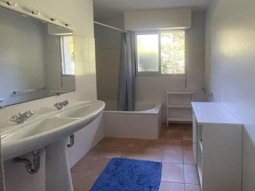 une salle de bain avec un lavabo, une baignoire et un miroir dans l'établissement Maison 110 m² Pyla-sur-Mer avec Terrasse et Jardin, proche plages - FR-1-420-161, à La Teste-de-Buch
