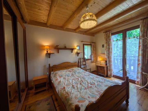 une chambre avec un lit et un lustre dans l'établissement Chalet familial 8 pers, calme, nature à Beaufort - FR-1-342-335, à Beaufort