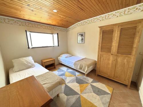 une chambre avec deux lits et un plafond en bois dans l'établissement Maison de charme au cœur du Moulleau, 4 couchages - FR-1-474-279, à Arcachon