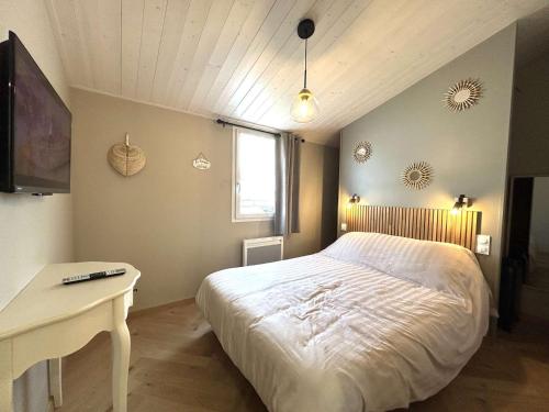 une chambre avec un lit, un bureau et une télévision dans l'établissement Maison 2 pièces à 600m de la mer avec parking privé - FR-1-224A-77, à Bretignolles-sur-Mer