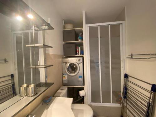 une salle de bain avec un lavabo et une machine à laver dans l'établissement T2 à 200m de la plage avec terrasse et parking - FR-1-413-258, à Capbreton
