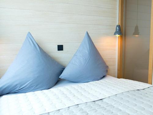 ein Bett mit zwei blauen Kissen darauf in der Unterkunft Lüttjer Kaiser Comfortable holiday residence in Norderney