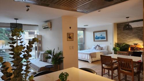 a living room with a bed and a dining room at Espectacular Departamento en Concord Pilar con cochera in La Lonja