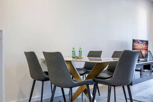 a dining room table with chairs and a laptop on it at Comfy 3 bed near DFO Sydney Olympic Park in Sydney