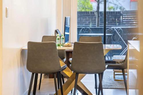 a table with four chairs and a table with a window at Comfy 3 bed near DFO Sydney Olympic Park in Sydney